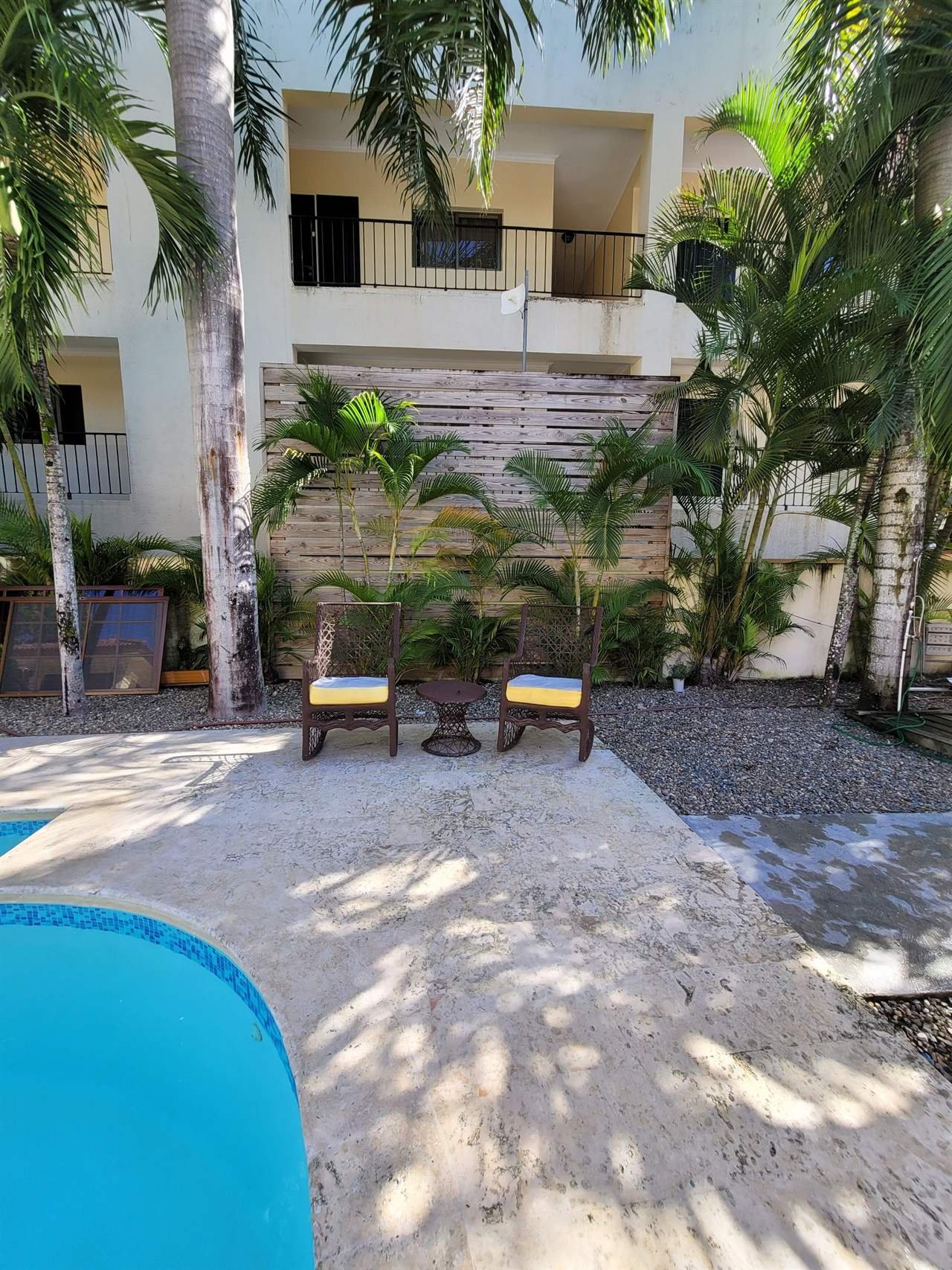 B&B Pavillion: wooden pool deck with two chairs and a small table